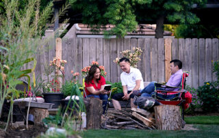 Misty Her, Phong Yang and their son, Ryan Yang, sit around the family fire pit.