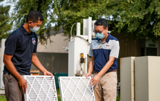 Vincent Malpaya, left, and Dr. Deify Law look at air filters used in an indoor air quality research project.