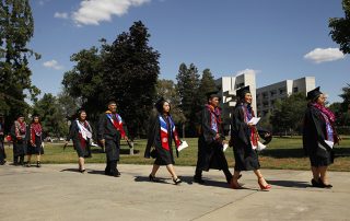 Hmong and Asian-Americans walking with their graduation gowns and caps.