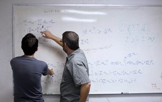 White board with equations on it.