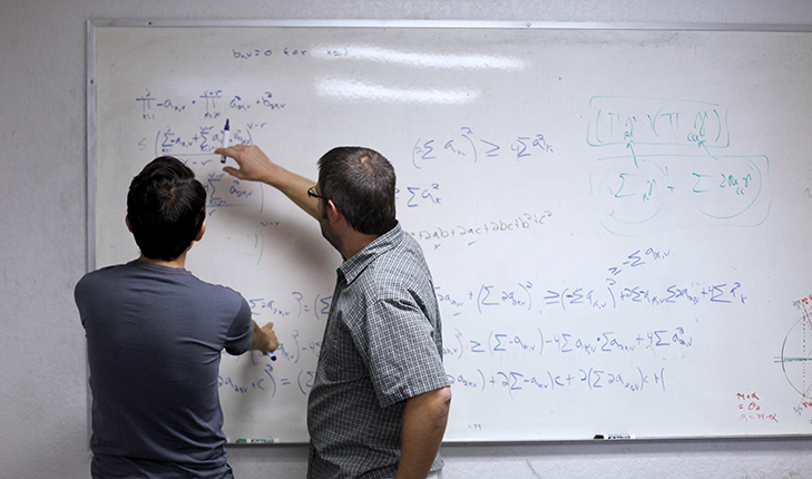 White board with equations on it.