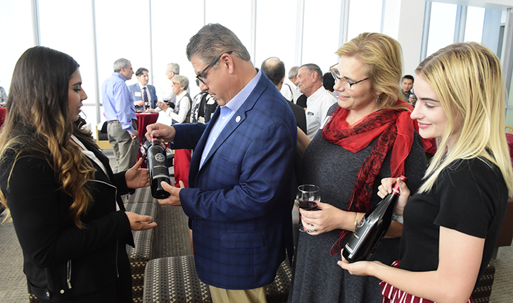 President Castro and Mary Castro reviewing campus wine