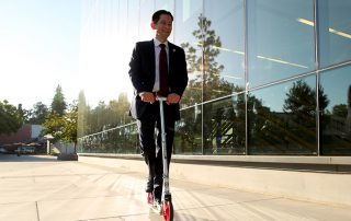 Provost Jiménez-Sandoval riding a scooter to get to his meeting.