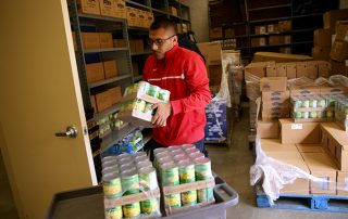 Young man stocks shelves at the Fresno State Student Cupboard.