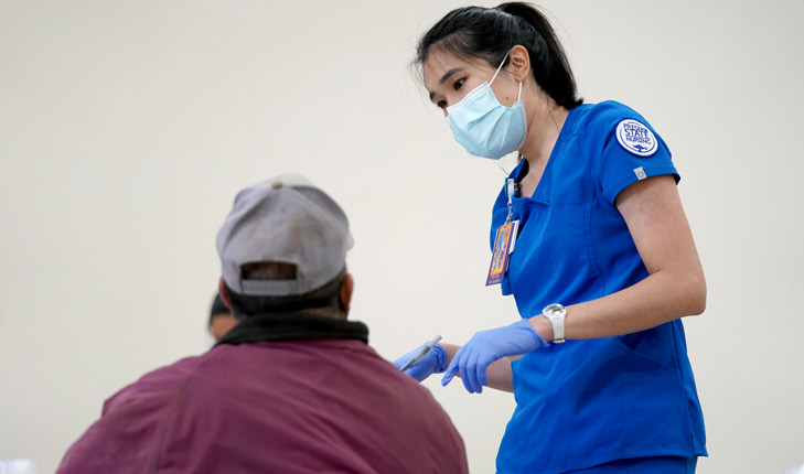 Nursing student Holly Vu works with a patient