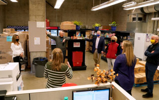 People, including donors Lou and Jane Amendola, gather in The Amendola Family Student Cupboard.