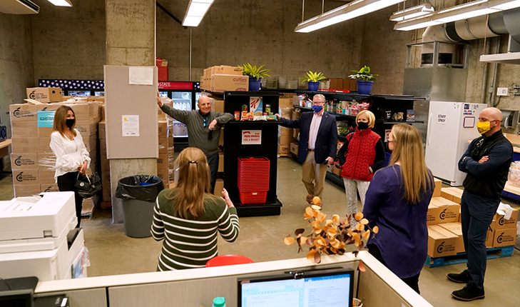 People, including donors Lou and Jane Amendola, gather in The Amendola Family Student Cupboard.