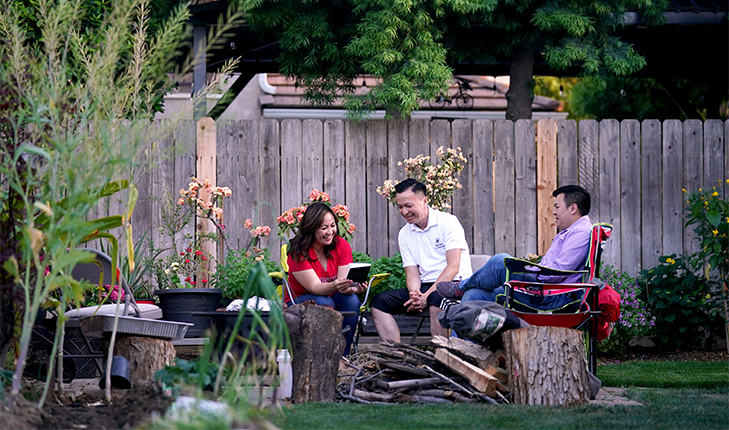 Misty Her, Phong Yang and their son, Ryan Yang, sit around the family fire pit.