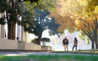 Masked students talk on campus