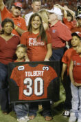The late former Fresno State football coach Jim Sweeney presented a plaque containing Otis Vincent Tolbert’s No. 30 jersey to Tolbert’s family on Sept. 10, 2005. (Photo by Joseph Hollak, courtesy of The Collegian)
