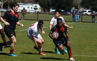 Fresno State rugby players competing against a rival team.
