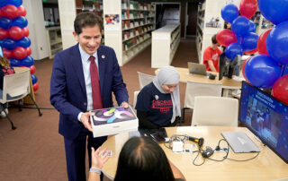 University President Saul Jimenez-Sandoval distributes an iPad to a new Fresno State student.