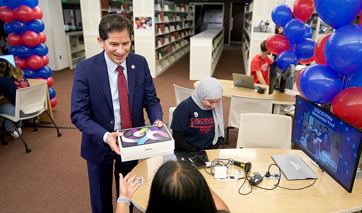 University President Saul Jimenez-Sandoval distributes an iPad to a new Fresno State student.