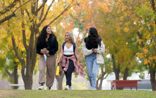 Three female students walking through campus.