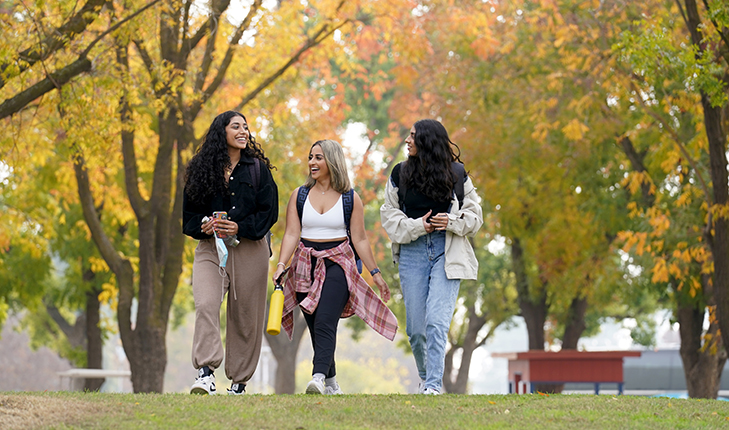 Three female students walking through campus.