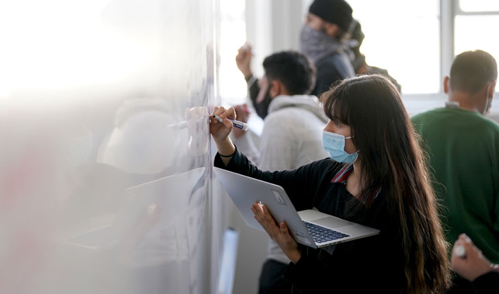 Students writing on whiteboard