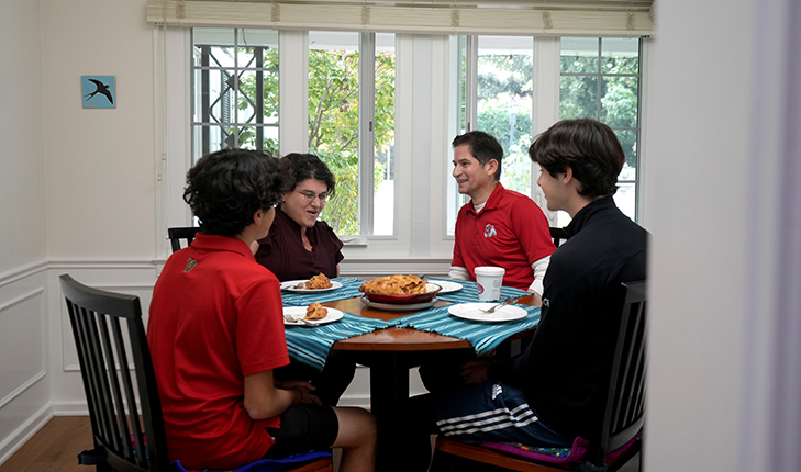 Fresno State President ​Saúl Jiménez-Sandoval, his wife Mariana Anagnostopoulos and their two sons, Arion and Leo sitting at their dining table.