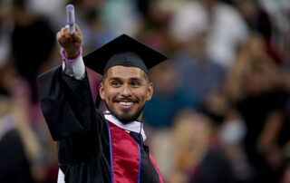 Graduating student points toward crowd.