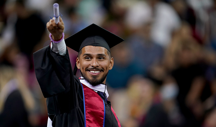 Graduating student points toward crowd.