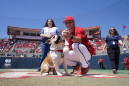 Fresno State pitcher Cooper Bergman plays with new live mascot Victor E. Bulldog IV before the passing of the collar ceremony.