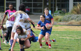 A group of girls playing rugby.