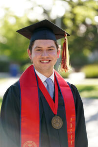 Portrait of Joshua Heupel in graduation cap and gown.