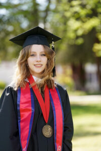 Portrait of Mialise Carney in graduation cap and gown.