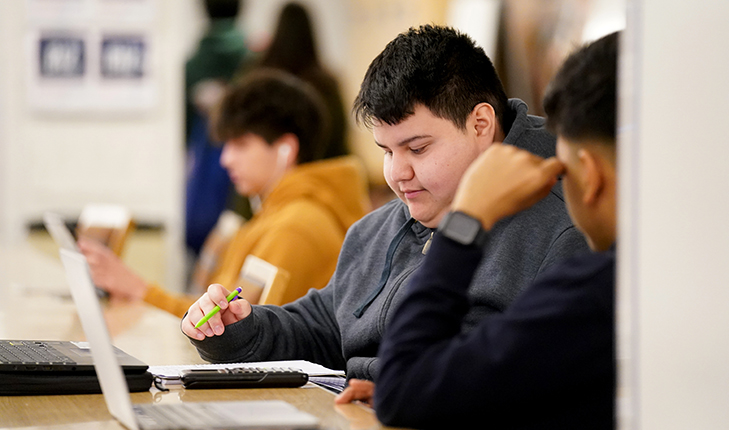 Students studying with a laptop open.