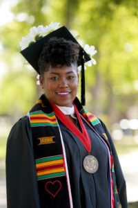 Portrait of Sade Johnson in graduation cap and gown.