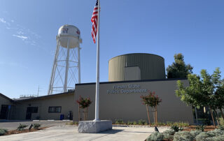 Flagpole in front of the Fresno State Police Department with the water tower in the background.