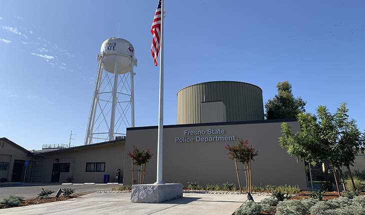 Flagpole in front of the Fresno State Police Department with the water tower in the background.