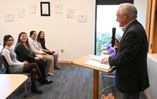 Jim Patterson at podium speaking to students