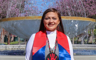 Fresno State student Noel Aguilar with a bright red and blue stole.