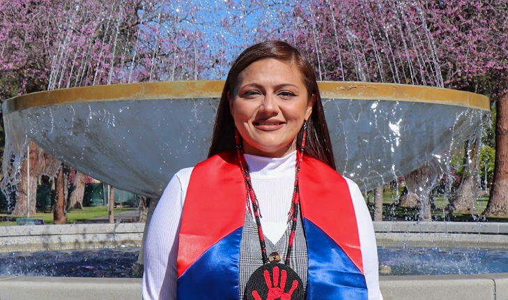 Fresno State student Noel Aguilar with a bright red and blue stole.