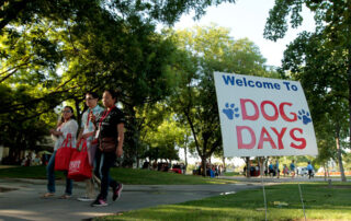 Students walking past dog days sign