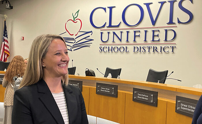 Dr. Corrine Folmer in front of "Clovis Unified School District" sign