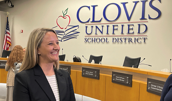 Dr. Corrine Folmer in front of "Clovis Unified School District" sign