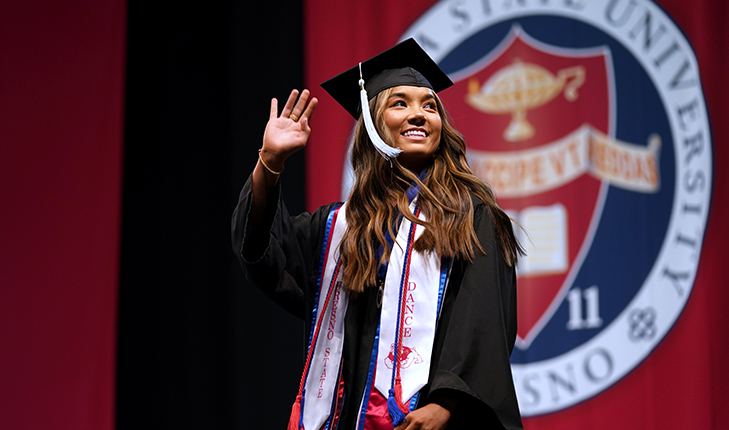 Student waving at graduation