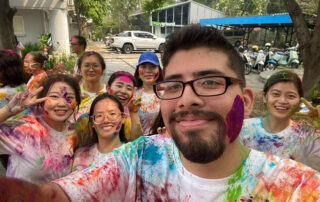 Ricardo Estrada Davila, with purple paint on his cheek, poses with friends while studying in Thailand.