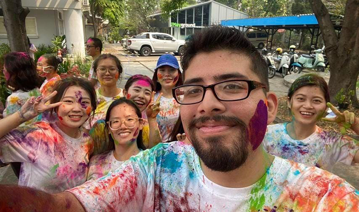 Ricardo Estrada Davila, with purple paint on his cheek, poses with friends while studying in Thailand.