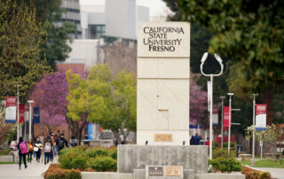 Campus shot of veteran's memorial sign and trees.