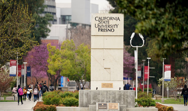 Campus shot of veteran's memorial sign and trees.