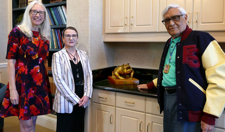 Joseph Guadalupe Garcia, the artist behind the iconic four-paw Bulldog logo, poses with a sculpture he created.