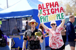 Two boys holding up sign "Alpha Sigma Phinapple"