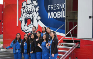 Students stand in front of new mobile health unit.