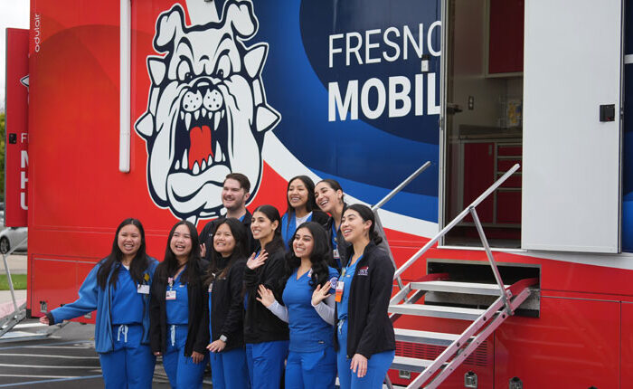 Students stand in front of new mobile health unit.