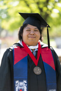 Angel Rojas, College of Social Sciences, in graduation robes.