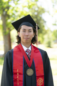 Logan X. Mouawangyee, College of Health and Human Services, in graduation robes.