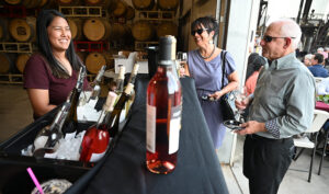 Fresno State enology graduate Malia Mora (left) serves Fresno State wine at a tasting.
