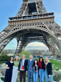 Psychology students stand with Dr. Chris Miller under the Eiffel Tower.